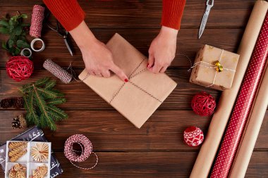 Kadın hediye paketi ve ahşap masa üzerindeki dekorasyon malzemeleri, yakın, üst görünüm.