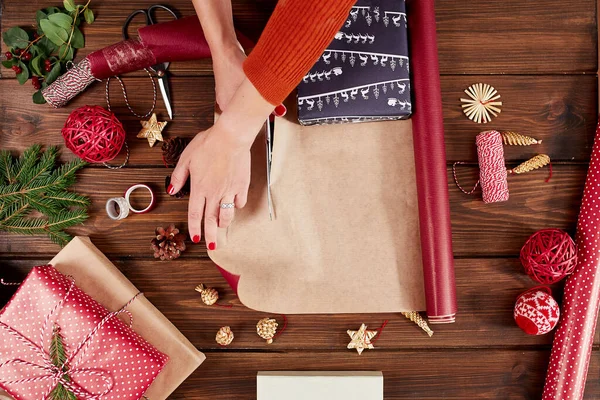 Coffret cadeau enveloppant femme avec des articles de décoration sur table en bois, gros plan, vue sur le dessus. — Photo
