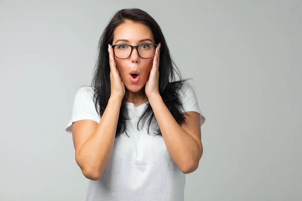 Gros plan de jeune femme en lunettes touchant les temples et regardant la caméra — Photo