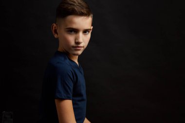 Siyah arka plandaki küçük çocuk.