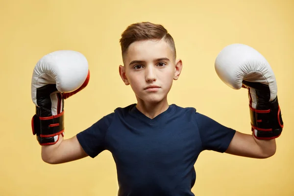 Kleines Kind mit großen Boxhandschuhen gewinnt Wettbewerb, gelber Hintergrund Studio — Stockfoto