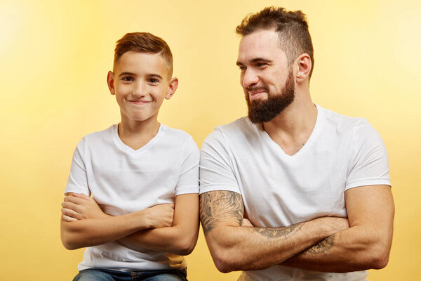 father and little son smiling at camera isolated on studio background