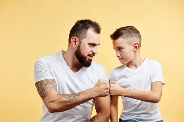 Pai e filho com sorriso agradável dão soco de punho um ao outro — Fotografia de Stock