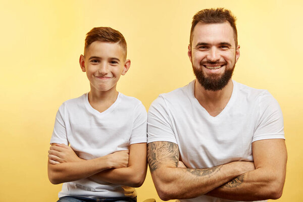 father and little son smiling at camera isolated on studio background
