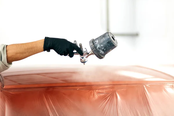 Auto pintor en ropa de trabajo protectora y respirador pintura carrocería del coche en la cámara de pintura — Foto de Stock