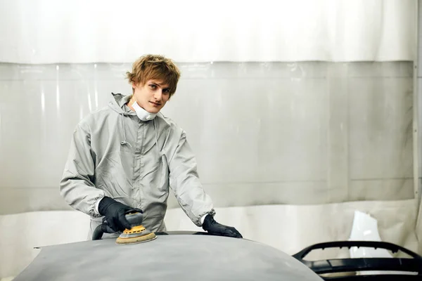 Mechanic grinds car part for painting. Car body work auto repair paint after accident — Stock Photo, Image