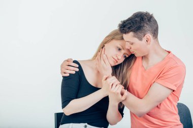 Genç bir koca karısına sarılıyor, sevgi dolu bir adam kadına nazikçe sarılıyor.