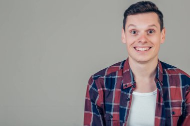 Mutlu genç adam. Kollarını kavuşturup gülümseyen yakışıklı bir gencin portresi.