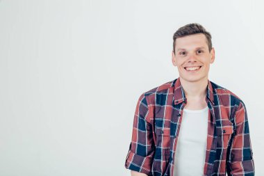 Mutlu genç adam. Kollarını kavuşturup gülümseyen yakışıklı bir gencin portresi.