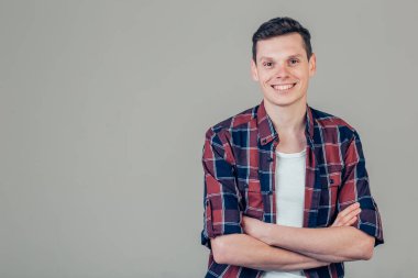 Yakışıklı genç adam kameraya bakıyor. Gülen genç adamın portresi