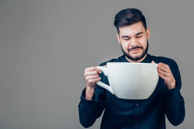 business man holding a funny huge and oversized cup of black coffee in caffeine clipart