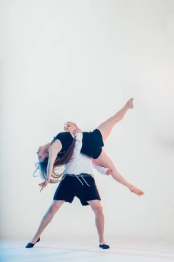 Modern tarz güzel dansçılar spor yapıyor. Genç adam kız arkadaşını tutuyor.