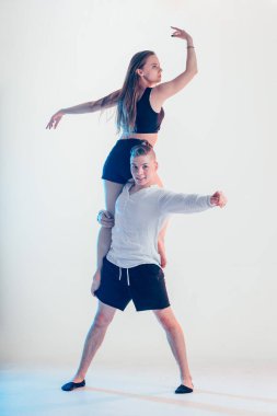 Modern tarz güzel dansçılar spor yapıyor. Genç adam kız arkadaşını tutuyor.