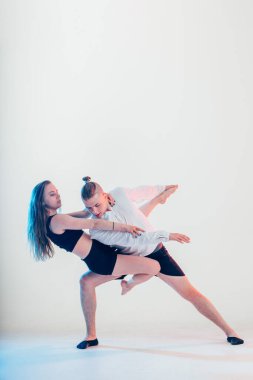 Modern tarz güzel dansçılar spor yapıyor. Genç adam kız arkadaşını tutuyor.