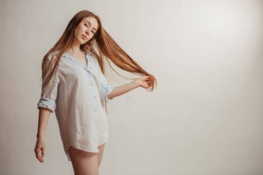 Uzun düz kızıl saçlı güzel bir kadın. Beyaz arkaplan üzerinde kadın model
