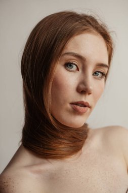 Uzun, düz saçlı, boynuna dolanmış bir kadın.