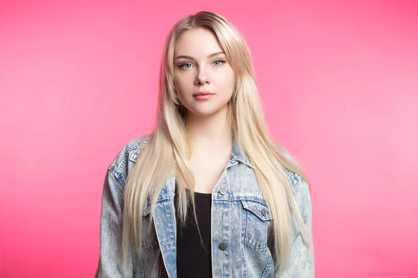 Pleasant blonde young woman looking at camera over pink background. — Stock Photo, Image