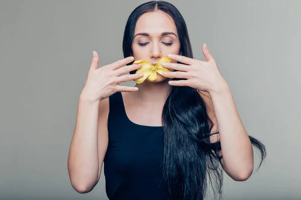 Labios y hombros de caucásico joven morena mujer con peonía flor en los labios — Foto de Stock