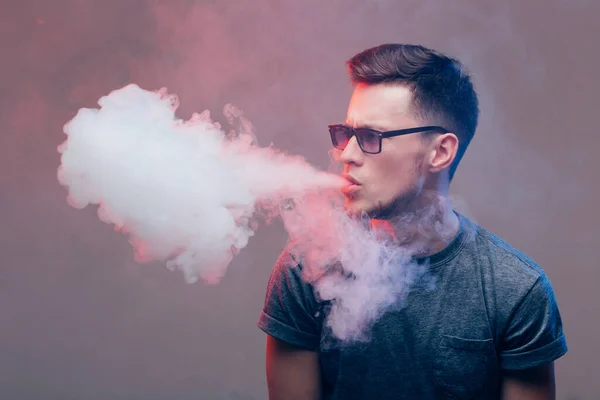 Człowiek z brodą wymiotujący elektronicznym papierosem. Vaper hipster dymu parownik. — Zdjęcie stockowe