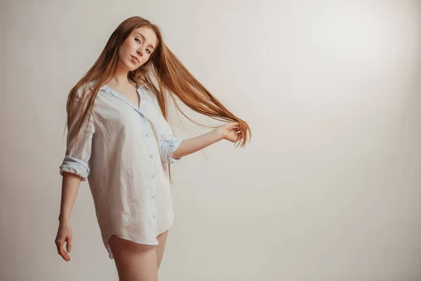 Mooie vrouw met lang recht rood haar. Vrouwelijk model over witte achtergrond — Stockfoto