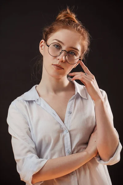 Ruiva modelo feminino em óculos posando no fundo preto — Fotografia de Stock