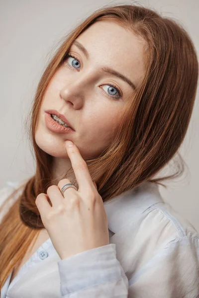 Kızıl saçlı, mavi gözlü, düşünceli bir kadın kameraya bakıyor. — Stok fotoğraf