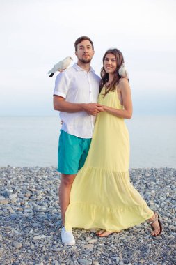 Parktaki çift yerel güvercinlerle oynuyor, turistler eğleniyor.