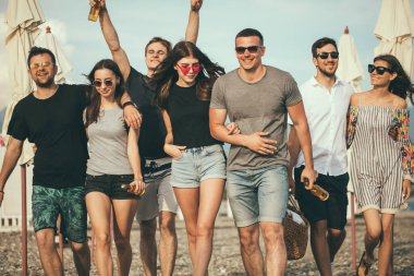 Tatil, tatil. Bir grup arkadaş sahilde eğleniyor, yürüyor, bira içiyor, gülümsüyor ve sarılıyorlar.