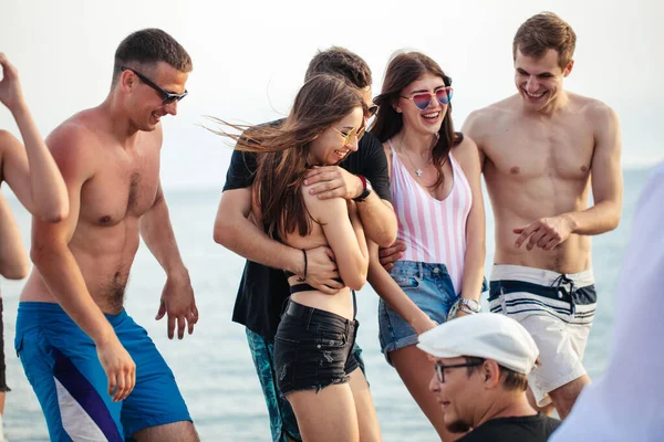 Baráti társaság Walking at Beach, szórakozás, nők piggyback on mans, vicces nyaralás — Stock Fotó