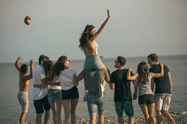 Felici uomini e donne camminano sulla spiaggia Gruppo di amici che si godono le vacanze al mare — Foto Stock