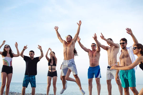 Barátok táncolnak a strandon napnyugta alatt napfény, szórakozás, boldog, élvezze — Stock Fotó