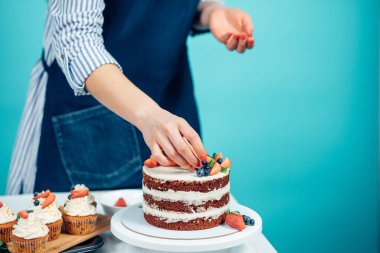 Lezzetli pastayı süsleyen kadın