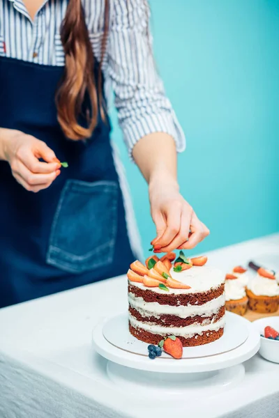 Mujer decoración delicioso pastel — Foto de Stock