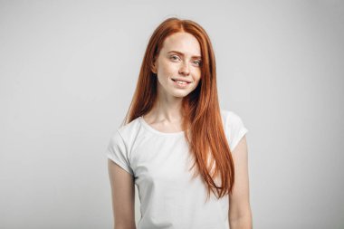 Kameraya bakıp gülümseyen mutlu kızıl kız.