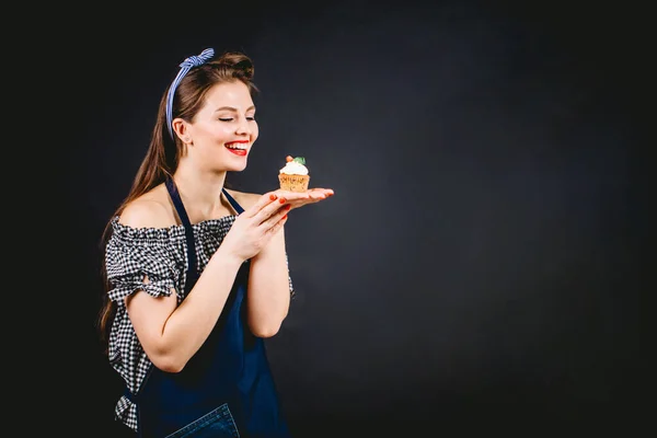 Hermosa pastelera mujer sosteniendo cupcake en las manos y dando diferentes emociones —  Fotos de Stock