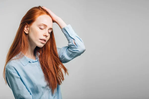 Ung söt rödhårig flicka med fräknar tittar på kameran ler rörande hår — Stockfoto