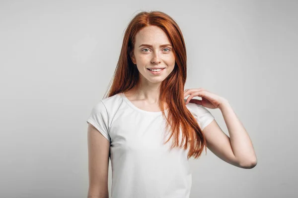 Schöne rothaarige Mädchen mit Sommersprossen lächelt in die Kamera. — Stockfoto