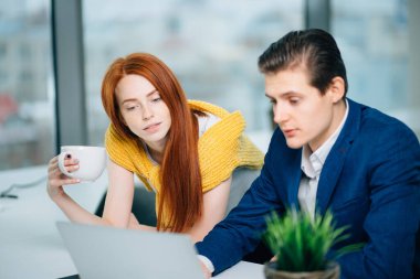 Dizüstü bilgisayarla çalışan iki iş ortağı..