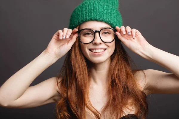 Mädchen lächelt mit geschlossenen Augen und berührt ihr rot gelocktes Haar auf weißem Hintergrund — Stockfoto