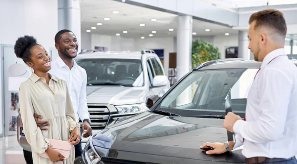 Confident caucasian salesperson selling cars at car dealership — Stock Photo, Image