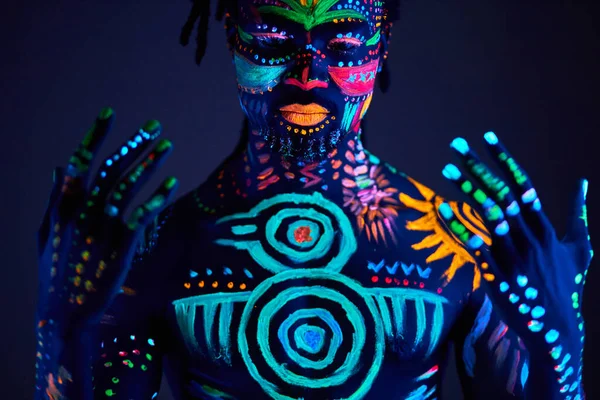 Conceptueel portret van de Afrikaanse mens geschilderd in fluorescerende UV kleuren — Stockfoto