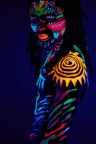 Close-up black female with fluorescent prints on skin, cosmic paint glowing  on neon lights Stock Photo by ©ufabizphoto 543170308