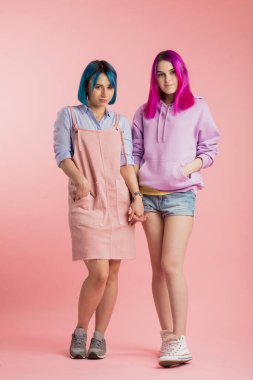 Genç ve çekici öğrenciler el ele tutuşup kameraya bakıyorlar.