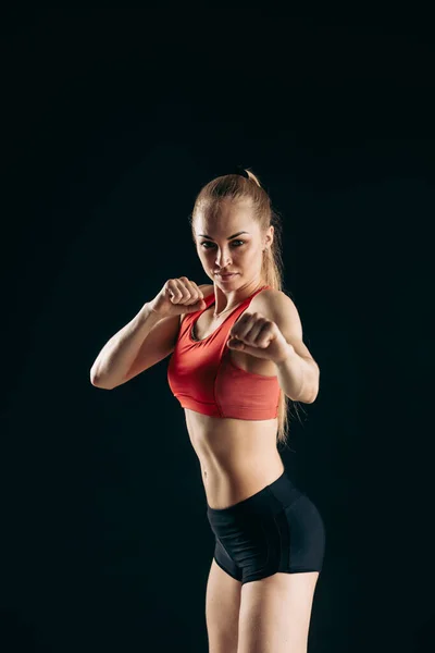 Selbstbestimmtes, selbstbewusstes blondes Mädchen mit geballten Fäusten beim Training im Fitnessstudio — Stockfoto