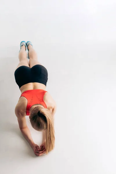 Ajuste actiav chica en ropa deportiva se apoya en sus codos y hacer ejercicios — Foto de Stock