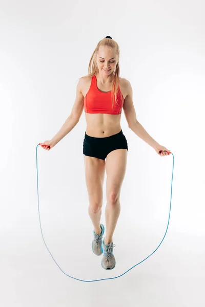 Foto de cuerpo entero. ajuste grl delgado está entrenando con saltar la cuerda — Foto de Stock
