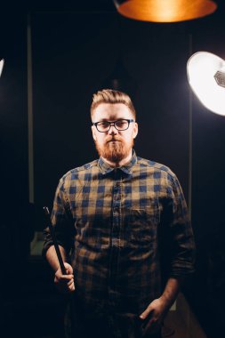 Genç gözlüklü kızıl adam elinde nargileyle