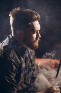 Barda sigara içen sarhoş genç adam.