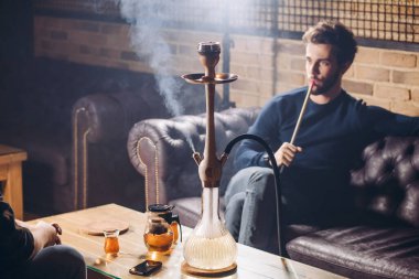 Yakışıklı bir adam barda vakit geçiriyor.