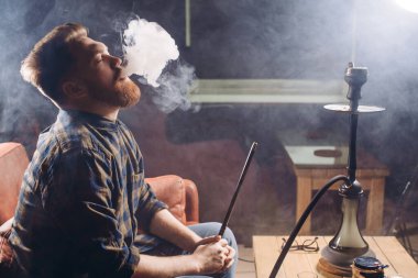 Kafede duman üfleyen kızıl duygusal bir adam.